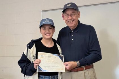 Scholarship winner Emily Jenkins holds certificate with Chamber Board President O'Neal Shelton.